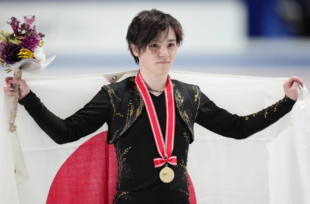 NHK杯男子で優勝し、メダルを胸に日の丸を掲げる宇野（撮影・菅敏）