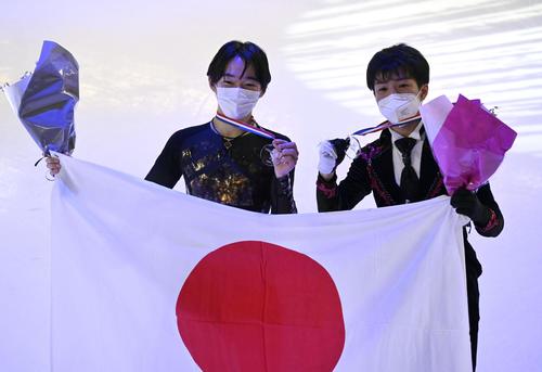 男子で優勝しメダルを掲げる鍵山優真（左）と2位の佐藤駿＝グルノーブル（共同）