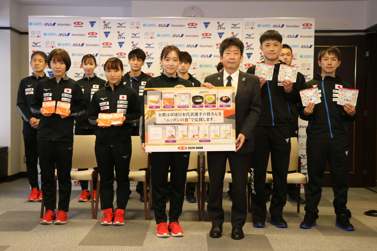 JA全農広報・調査部新妻成一部長（右から4人目）と贈呈された「ニッポンの食」を手に笑顔の日本代表選手