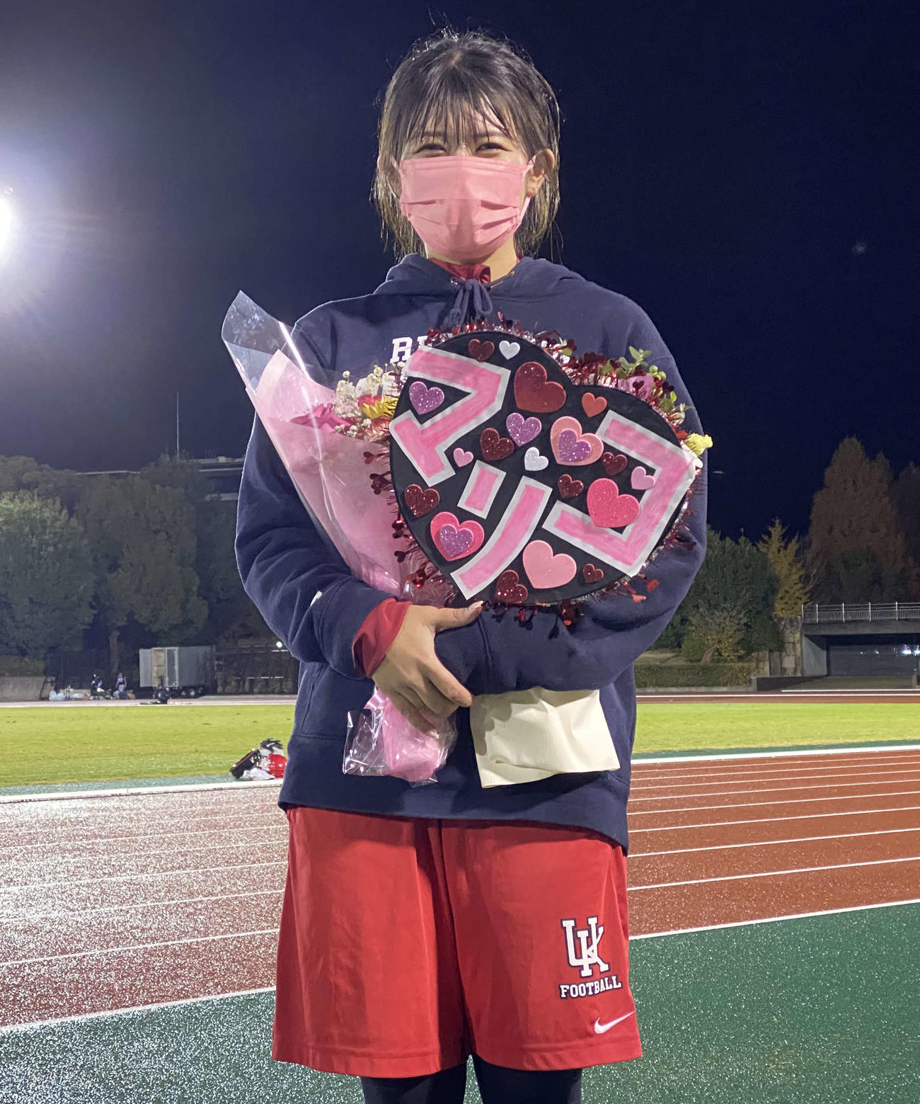 昇格が決まり、友人から花束を受け取り笑顔の久門茉莉子トレーナー（撮影・三宅ひとみ