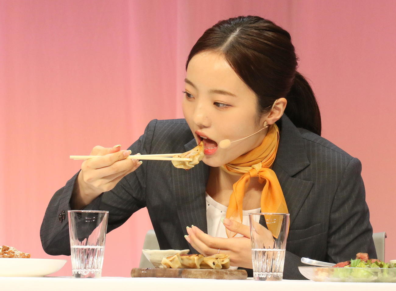 タウングループの試食コーナーで「最も好き」というギョーザを口にする本田真凜（撮影・木下淳）