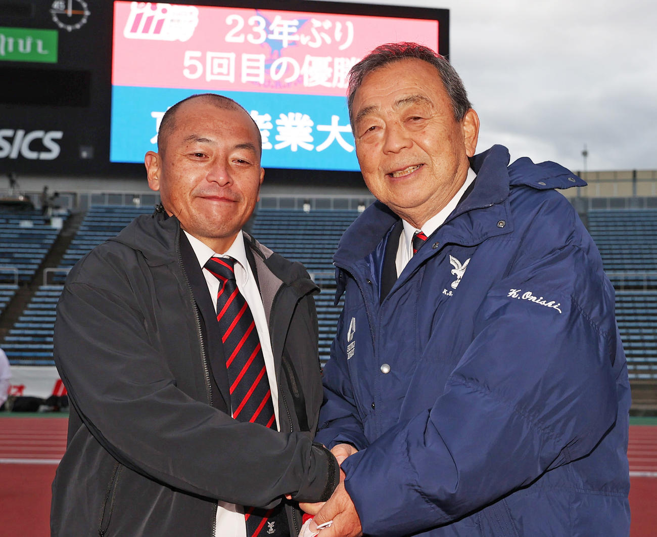 リーグ優勝を果たし握手を交わす京産大・広瀬監督（左）と大西元監督（撮影・清水貴仁）