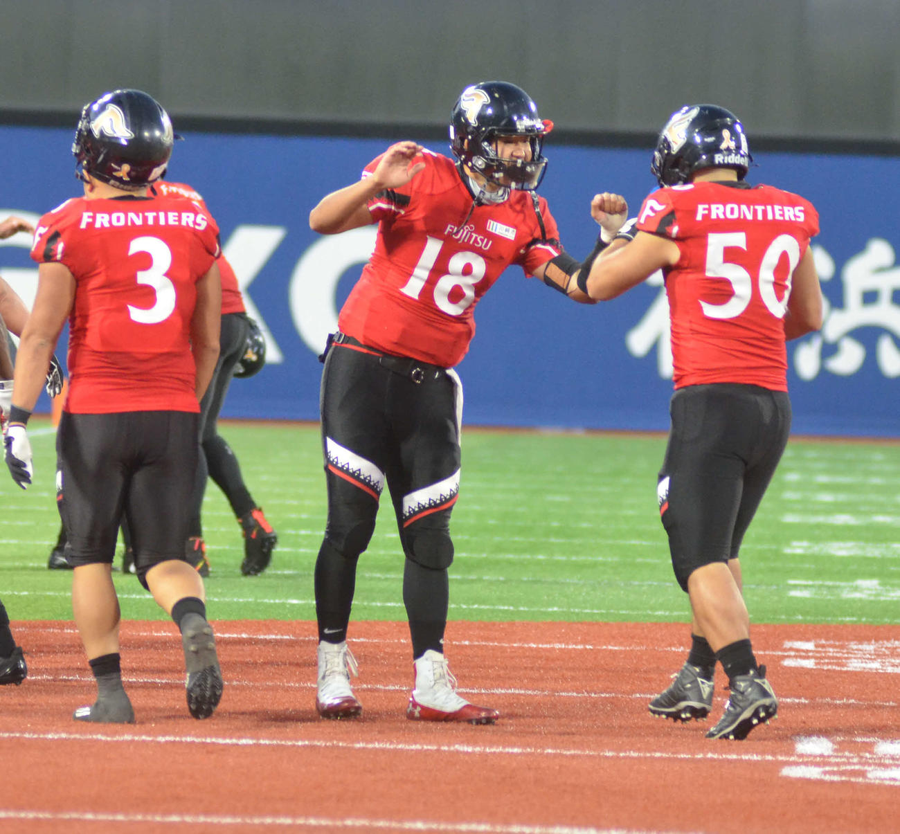 勝利が決まり、チームメートを迎える富士通QB高木翼（中央）（撮影・吉池彰）