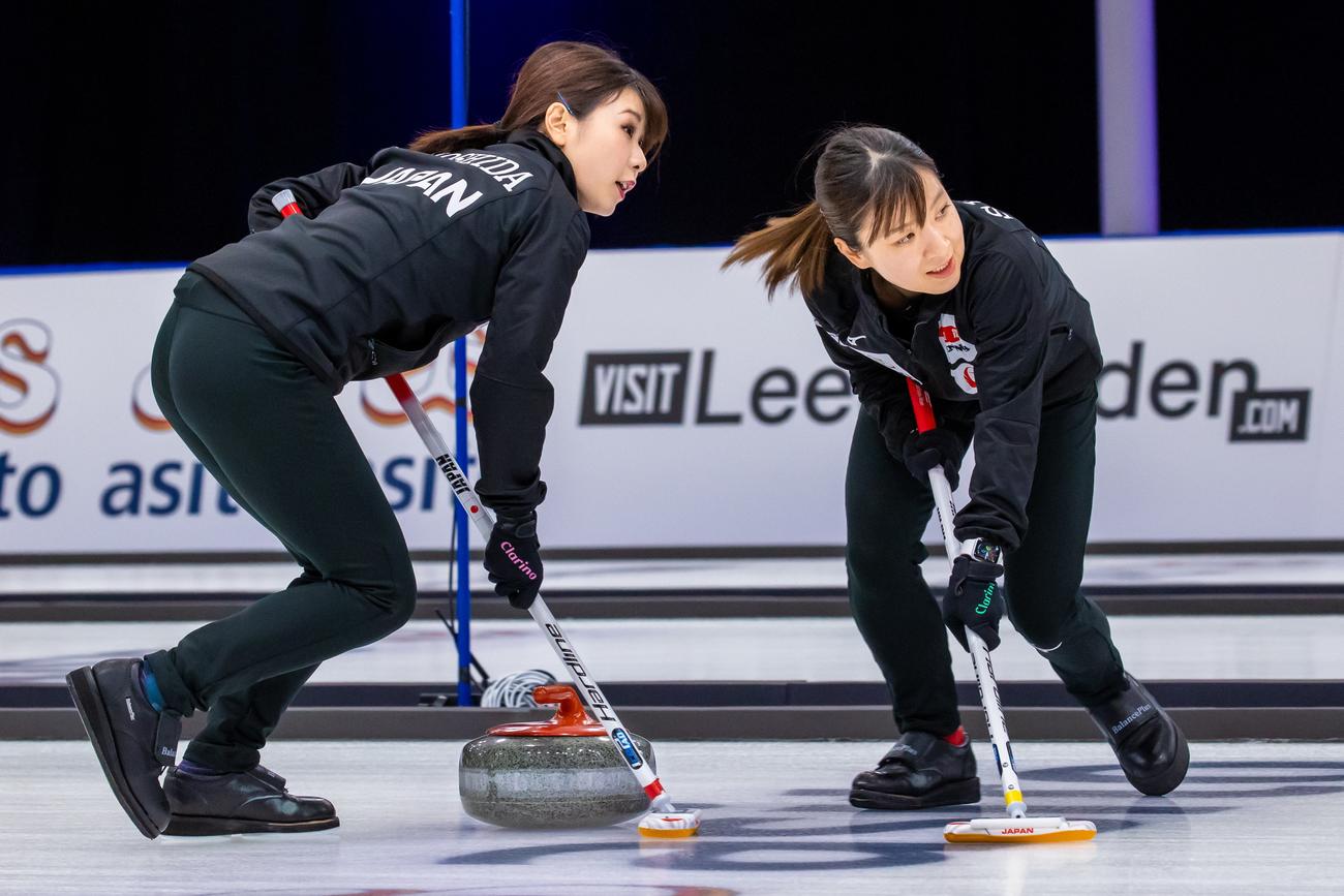 ラトビア戦でスイープする吉田夕と鈴木（ｃ） WCF / Steve Seixeiro