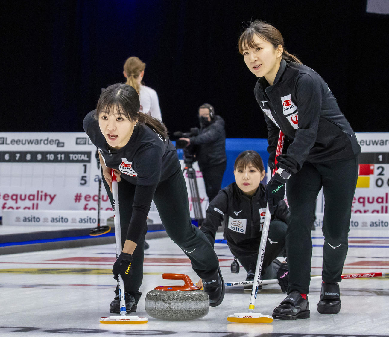 女子1次リーグ　ラトビア戦でプレーするロコ・ソラーレの（左から）吉田知、吉田夕、鈴木（共同）