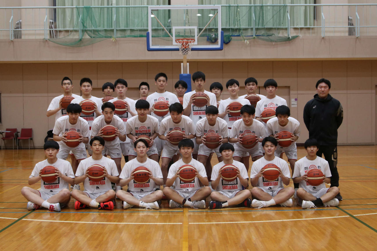 ボールを手に引き締まった表情を見せる白樺学園の選手と宮下監督（中列右）（撮影・山崎純一）