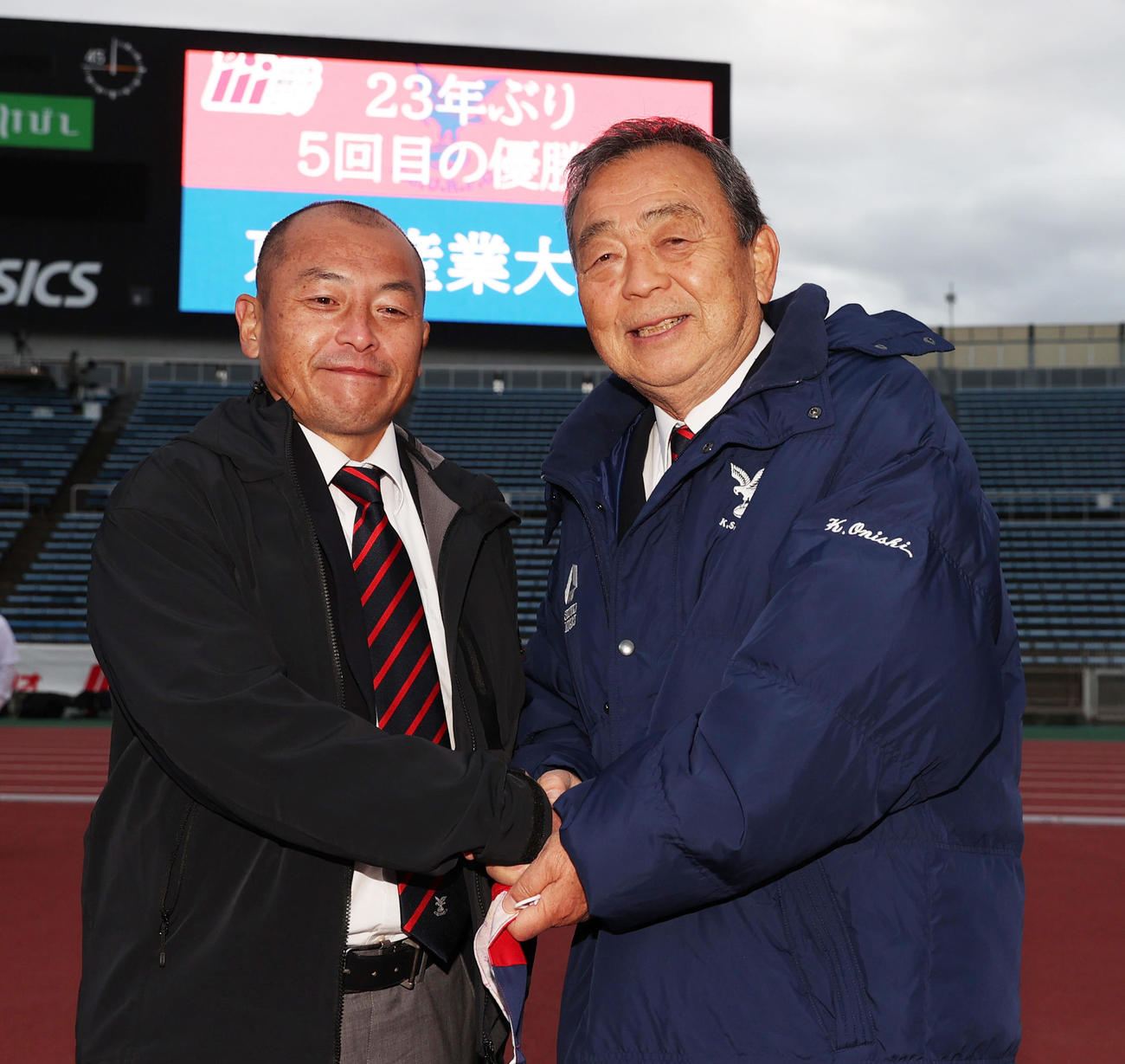 リーグ優勝を果たし握手を交わす京産大広瀬監督（左）と大西元監督＝2021年12月4日
