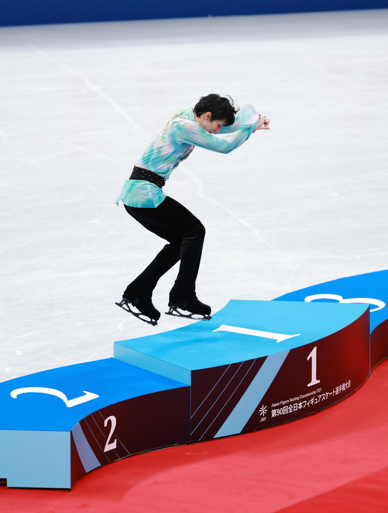 男子で優勝し表彰台に飛び乗る羽生（撮影・垰建太）