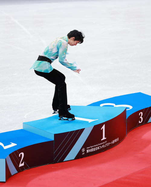 男子で優勝し表彰台に飛び乗る羽生（撮影・垰建太）