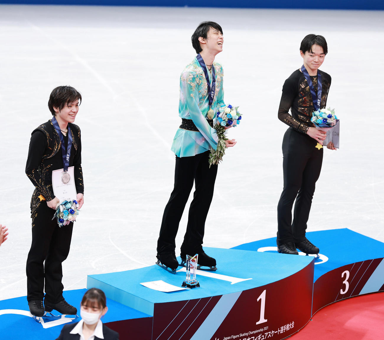 優勝した羽生は表彰台で笑顔を見せる。左は2位の宇野、右は3位の鍵山（撮影・垰建太）