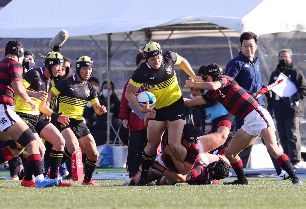 前半、仙台育英CTB草野（右から3人目）はタックルを受けながら前進する