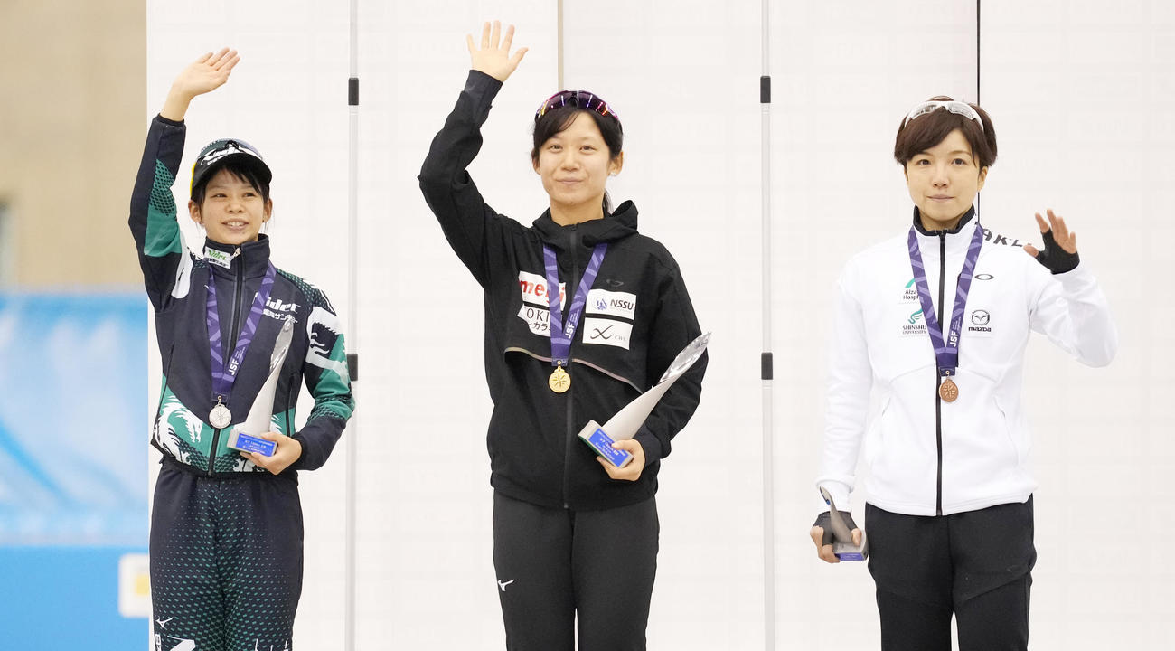 女子1500メートルで優勝し2位の高木菜那（左）、小平（右）とスタンドに手を振る高木美帆（撮影・菅敏）