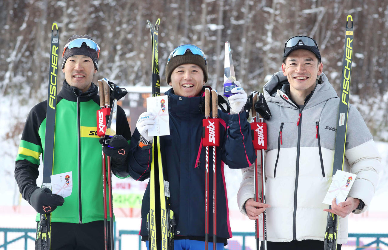 男子10キロフリーで優勝し笑顔の山下（中央）。左は2位宇田、右は3位宮沢（撮影・黒川智章）