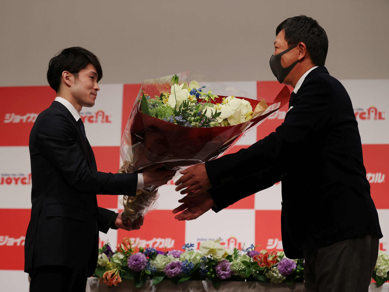 現役引退会見を終えジョイカル中村会長（右）から花束を受け取る内村（撮影・河野匠）