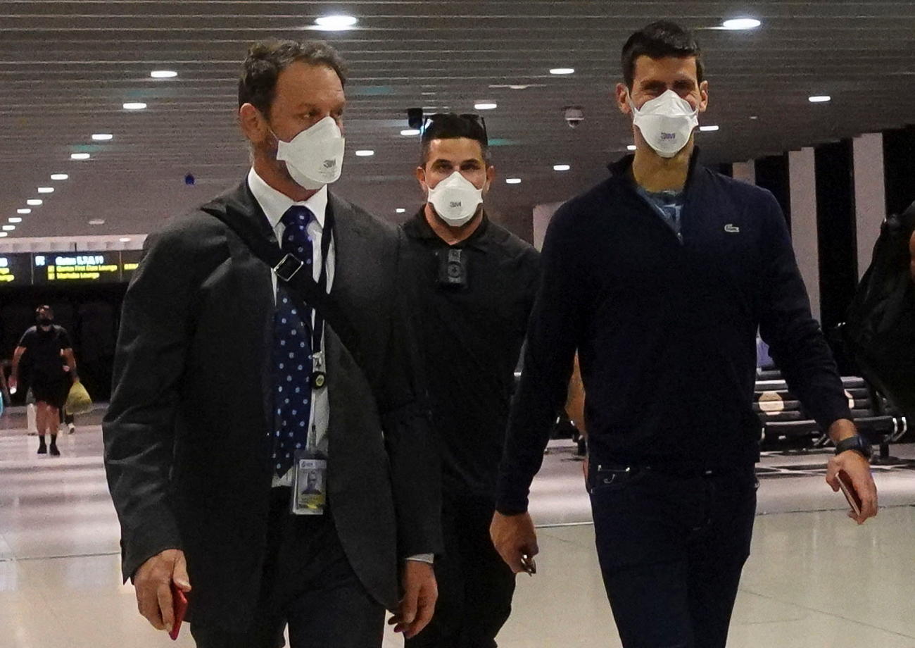 メルボルン空港から出国するジョコビッチ（右）（ロイター）