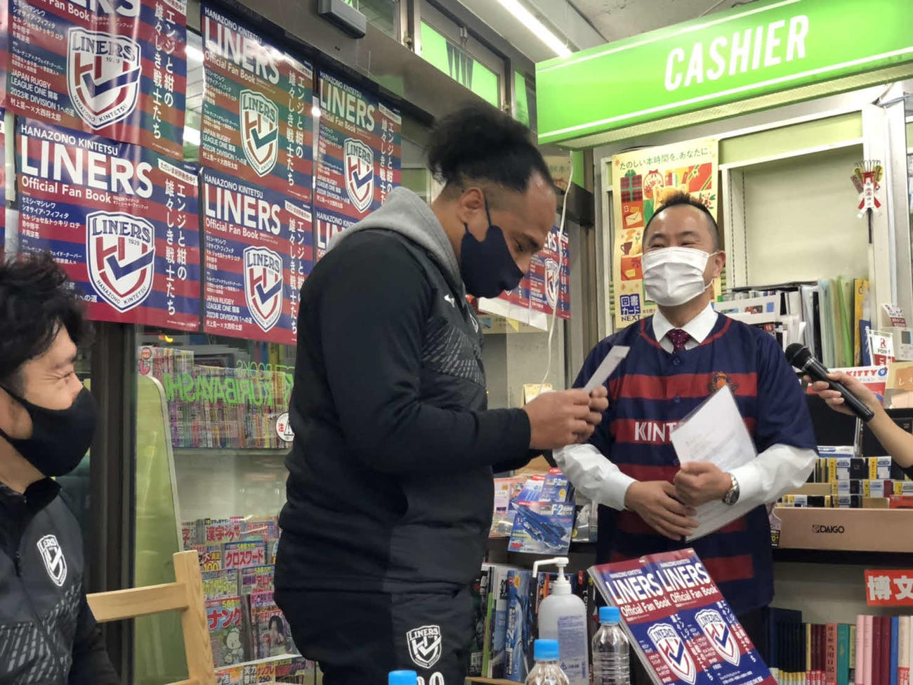 栗林書房の栗林秀一社長（右）から義援金を受け取るタウファ統悦さん（撮影・益子浩一）
