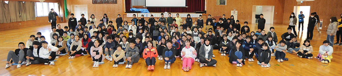 メダルを見せながら6年生との記念撮影に納まる村上さん（前列中央左）