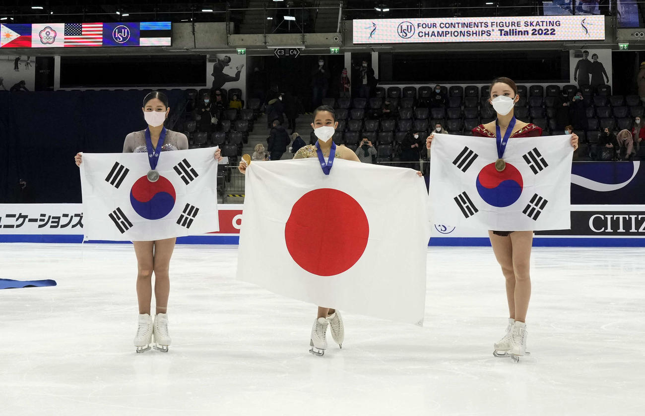 女子で優勝し、表彰式で日の丸を手にする三原舞依（中央）（ロイター）
