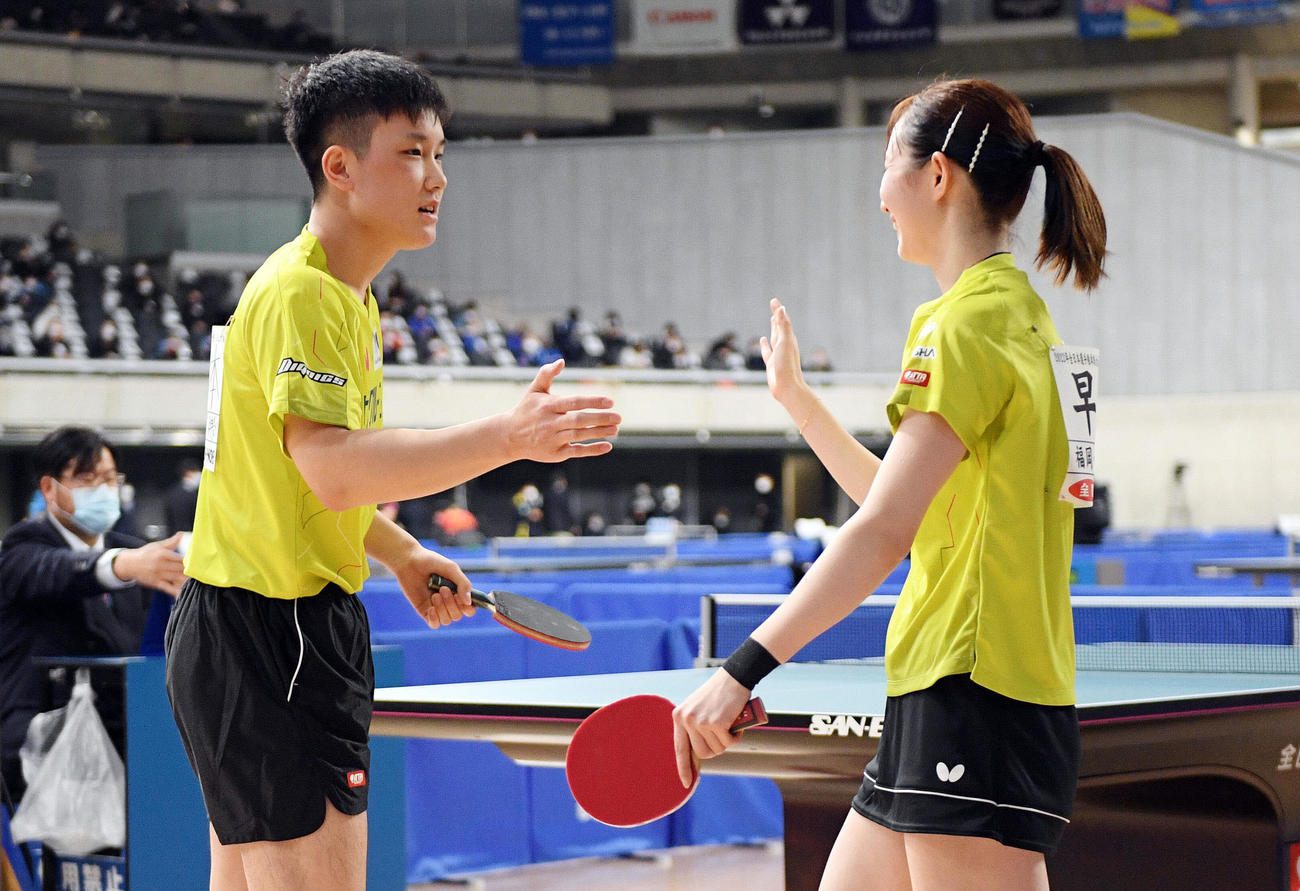 混合ダブルス3回戦で試合に勝利しタッチを交わす張本智（左）と早田（撮影・滝沢徹郎）