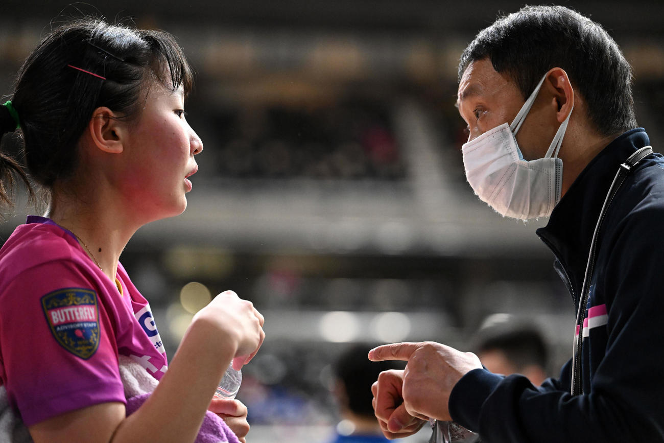 ジュニア女子4回戦でアドバイザーで父の宇さん（右）の話を聞く張本美（撮影・滝沢徹郎）