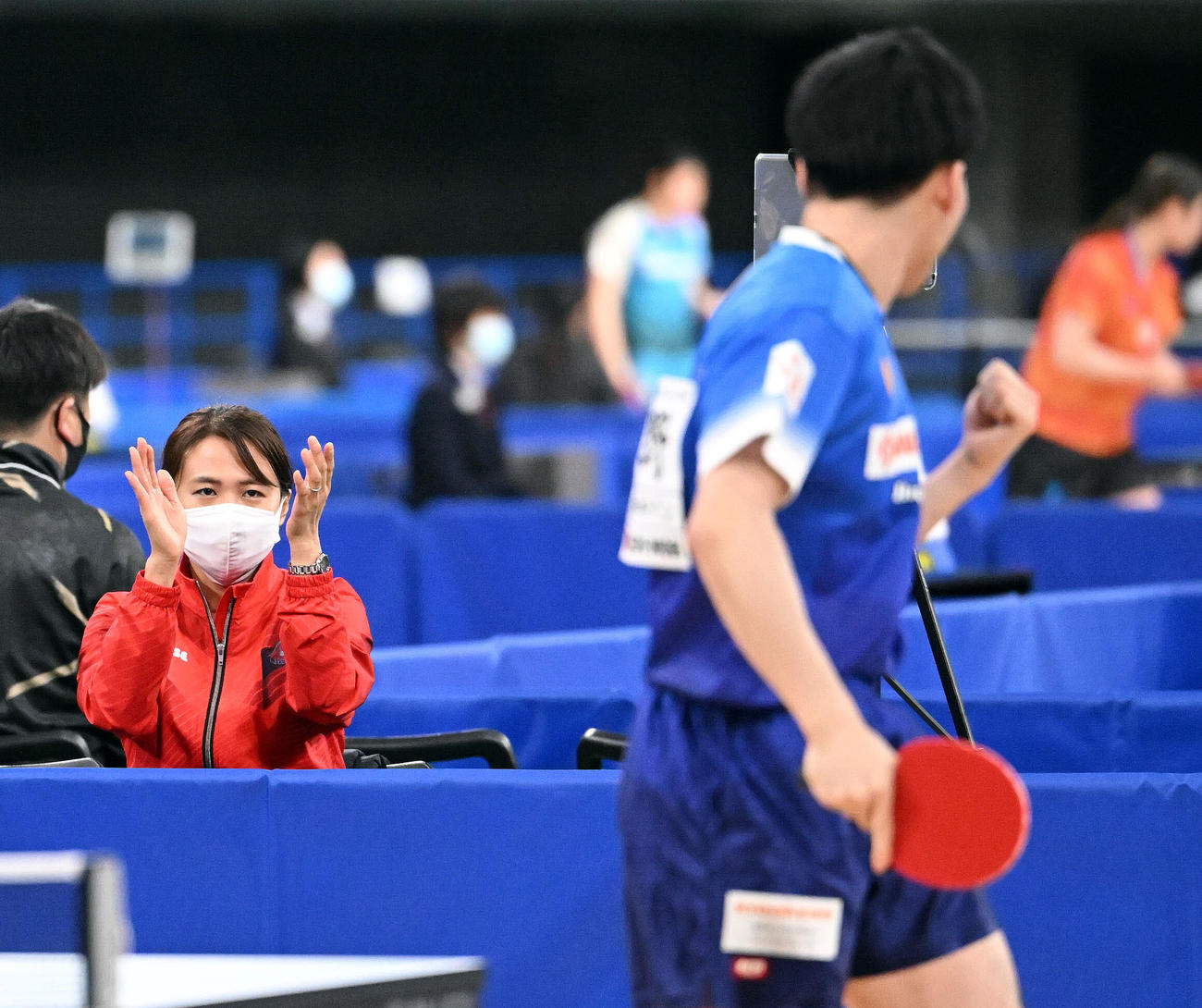 男子シングルス2回戦で弟の平野（手前）がポイントを奪い拍手するアドバイザーの早矢香さん（撮影・滝沢徹郎）