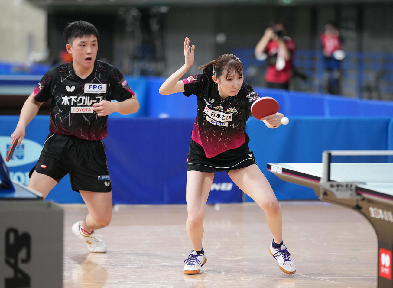 第3セット、ボールを打ち返す早田。左は張本智（撮影・鈴木みどり）