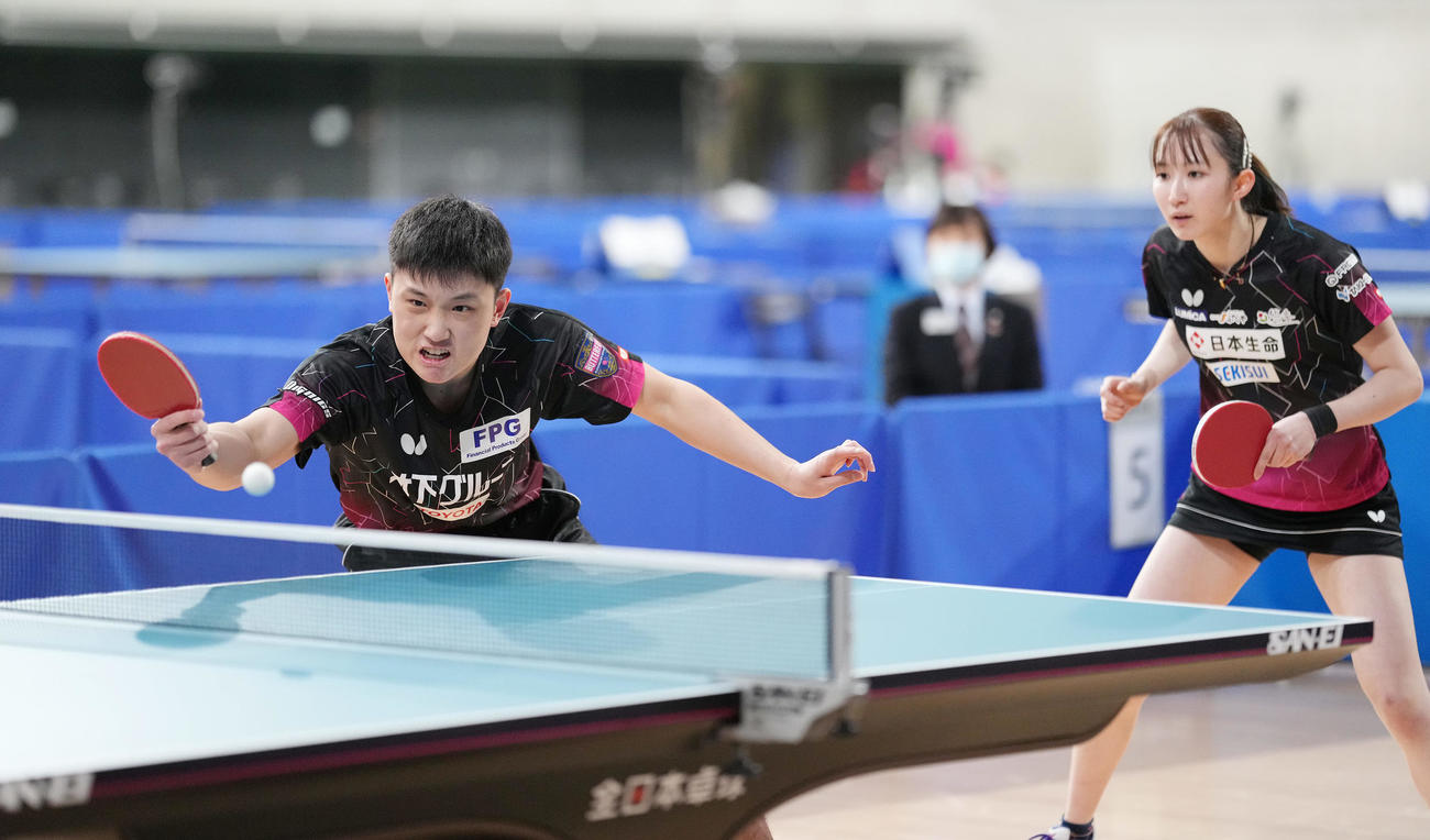 第1セット、ボールを打ち返す張本智。右は早田（撮影・鈴木みどり）