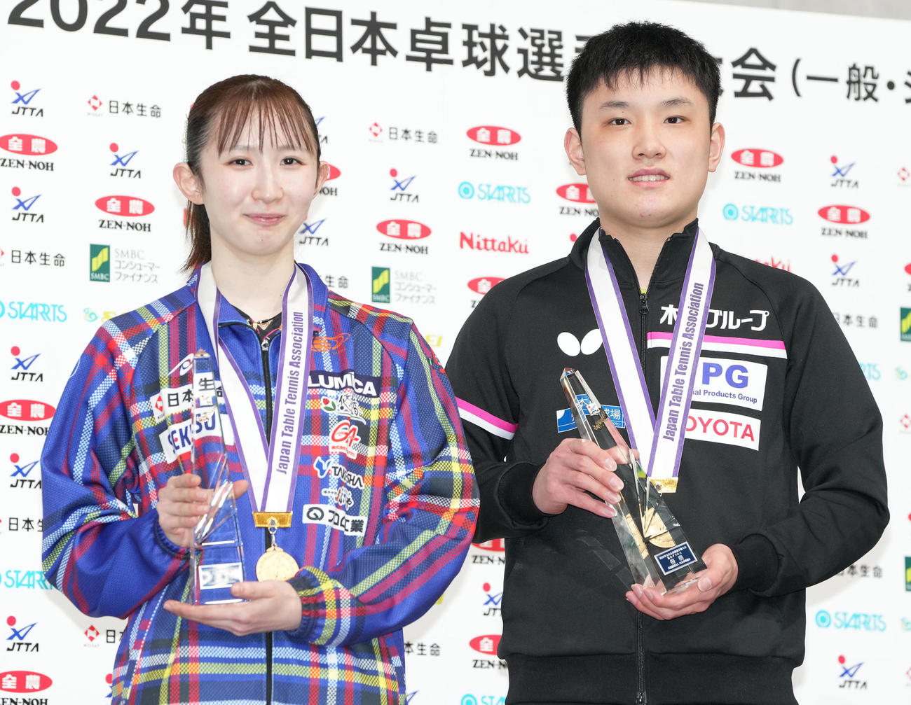 混合ダブルスで優勝し、トロフィーを手に笑顔の張本智（右）、早田組（撮影・鈴木みどり）