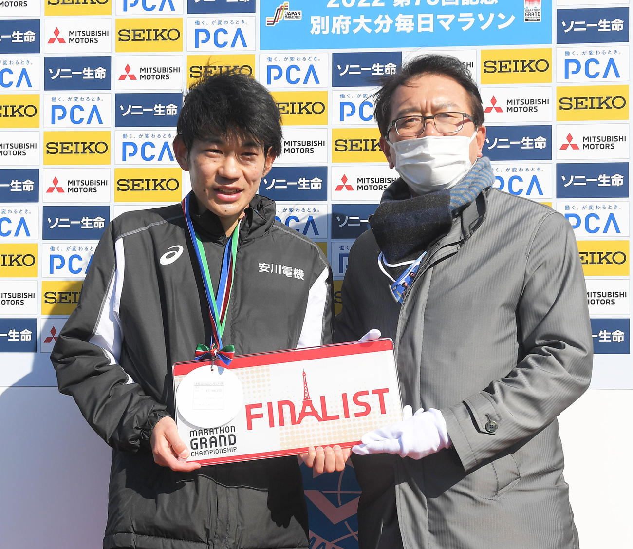 瀬古利彦・日本陸上競技連盟ロードランニングコミッションリーダー（右）からМGCチケットを渡される古賀淳紫（代表撮影）