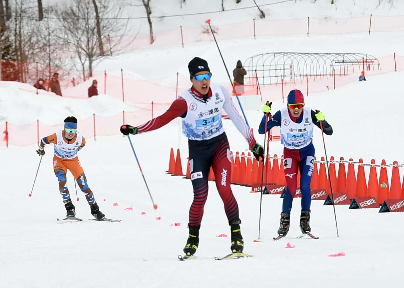 男子距離40キロリレーで3位に入りガッツポーズを見せる花輪・成田（中央）
