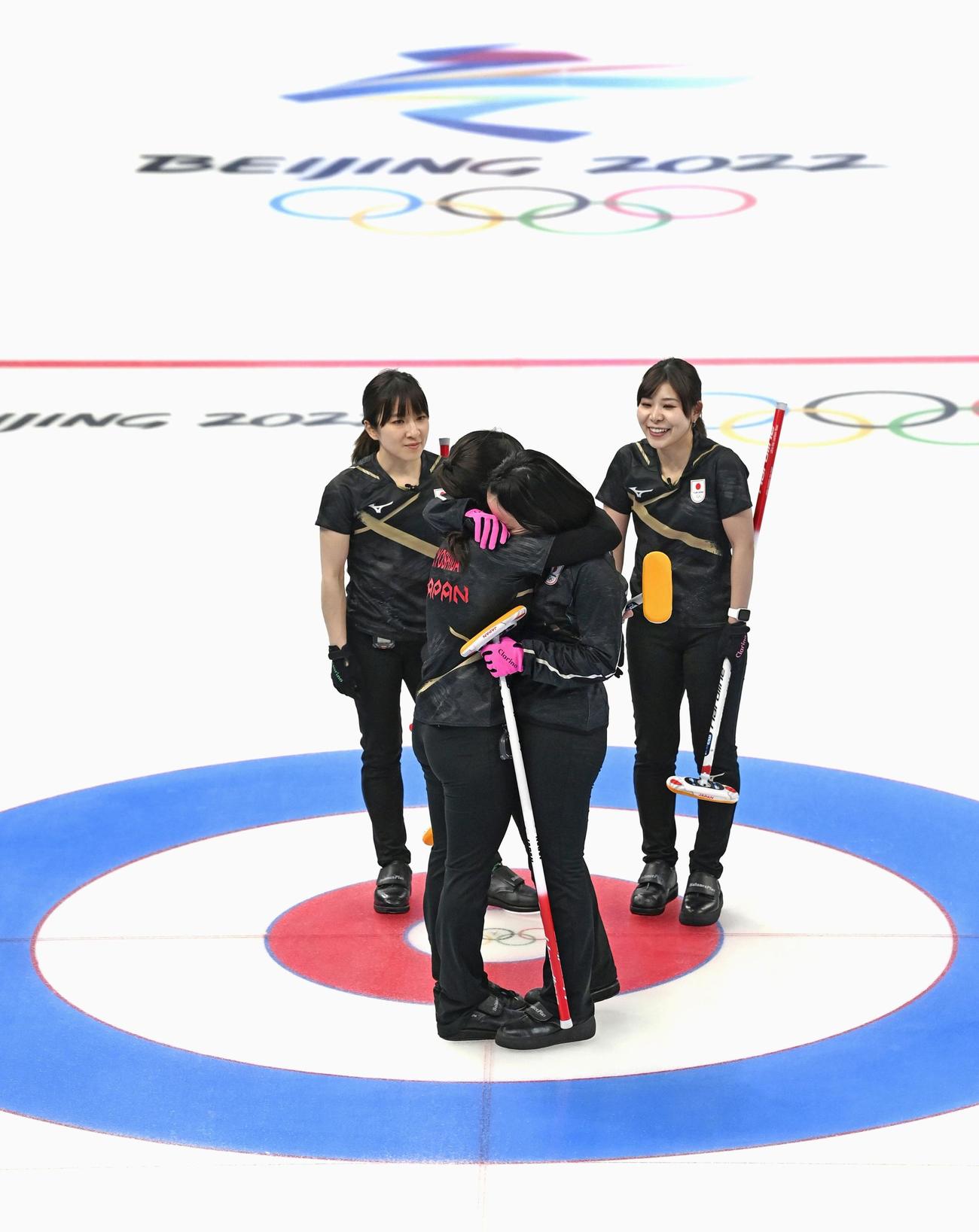 女子1次リーグ最終戦でスイスに敗れ、抱き合う吉田知（左）と藤沢。奥は鈴木（左）と吉田夕。この後準決勝進出が決まった（共同）