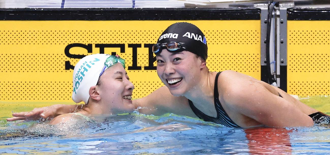 女子200 メートル 個人メドレー決勝のレースを終え、健闘をたたえ合う大橋悠依（左）と大本里佳（共同）
