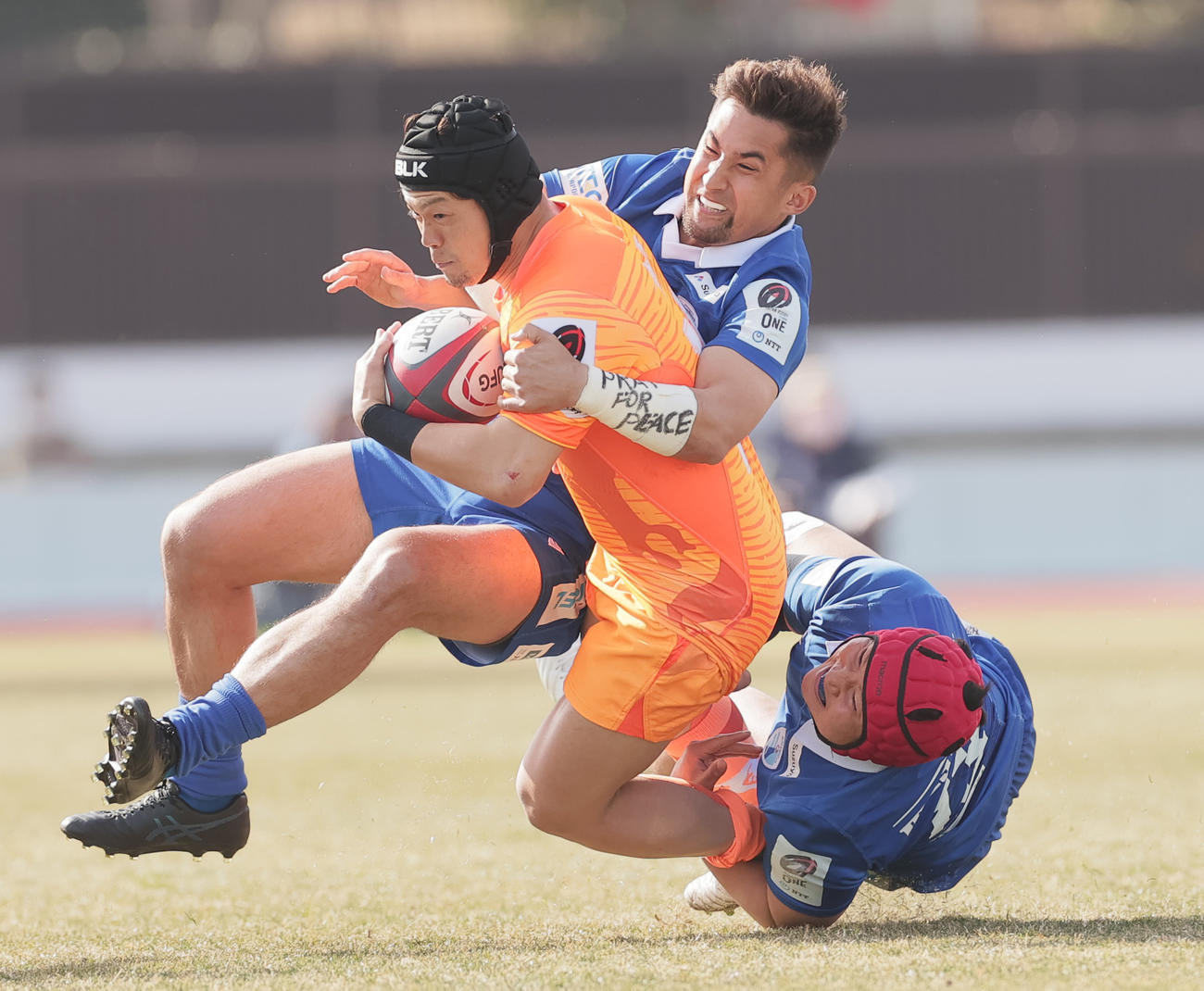 リーグワン　東京ベイ対静岡　前半、東京ベイWTB根塚（左）にタックルする静岡WTB中井。ウクライナ人の母を持つ中井の左手テーピングには「PRAY FOR PEACE（平和を祈る）と書かれていた（撮影・野上伸悟）