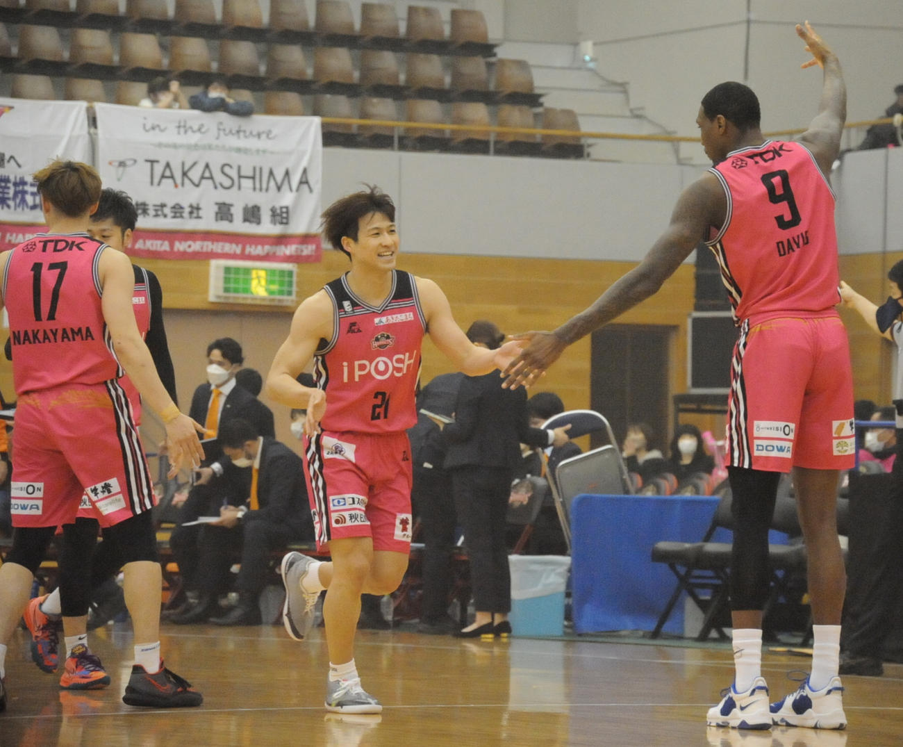 連続得点を挙げた秋田・長谷川（中央）は、デイビスと笑顔で手を合わせる