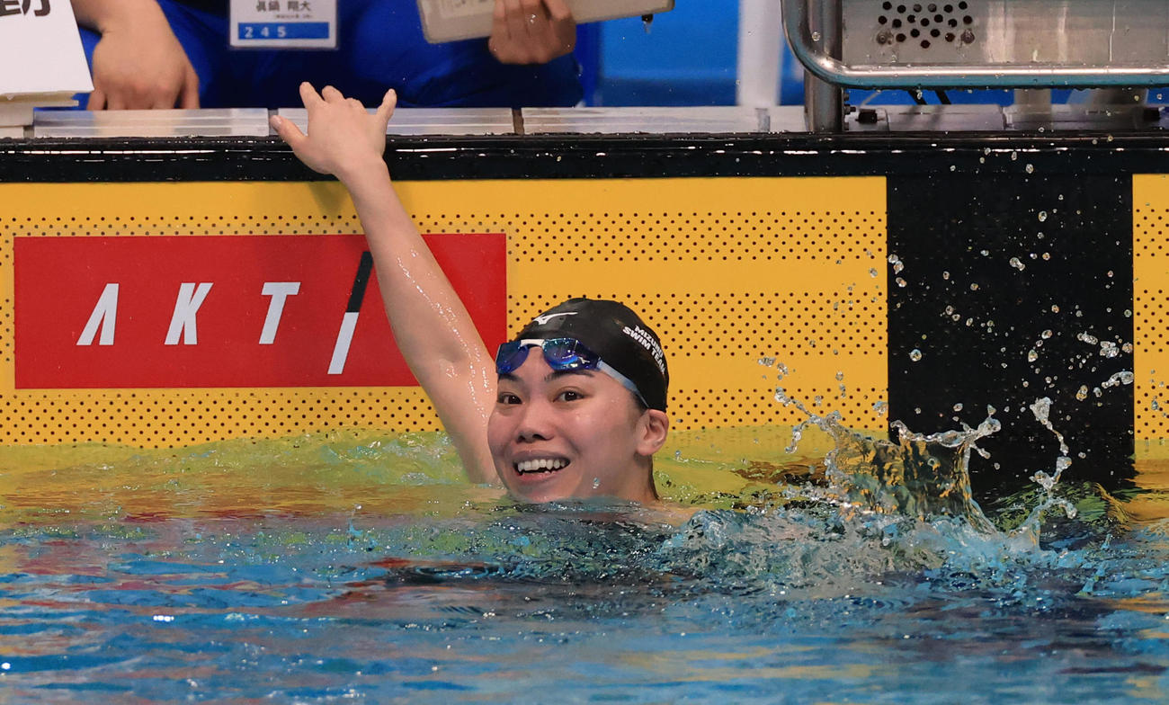 女子100メートル平泳ぎで優勝し、笑顔を見せる青木
