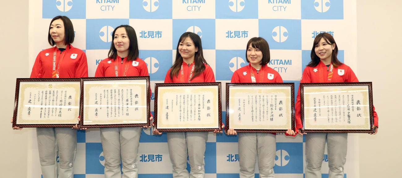 北見市役所を表敬訪問し、市民特別栄誉賞を受賞し笑顔で記念撮影に応じる左からロコ・ソラーレの石崎、藤沢、吉田知、鈴木、吉田夕（撮影・佐藤翔太）