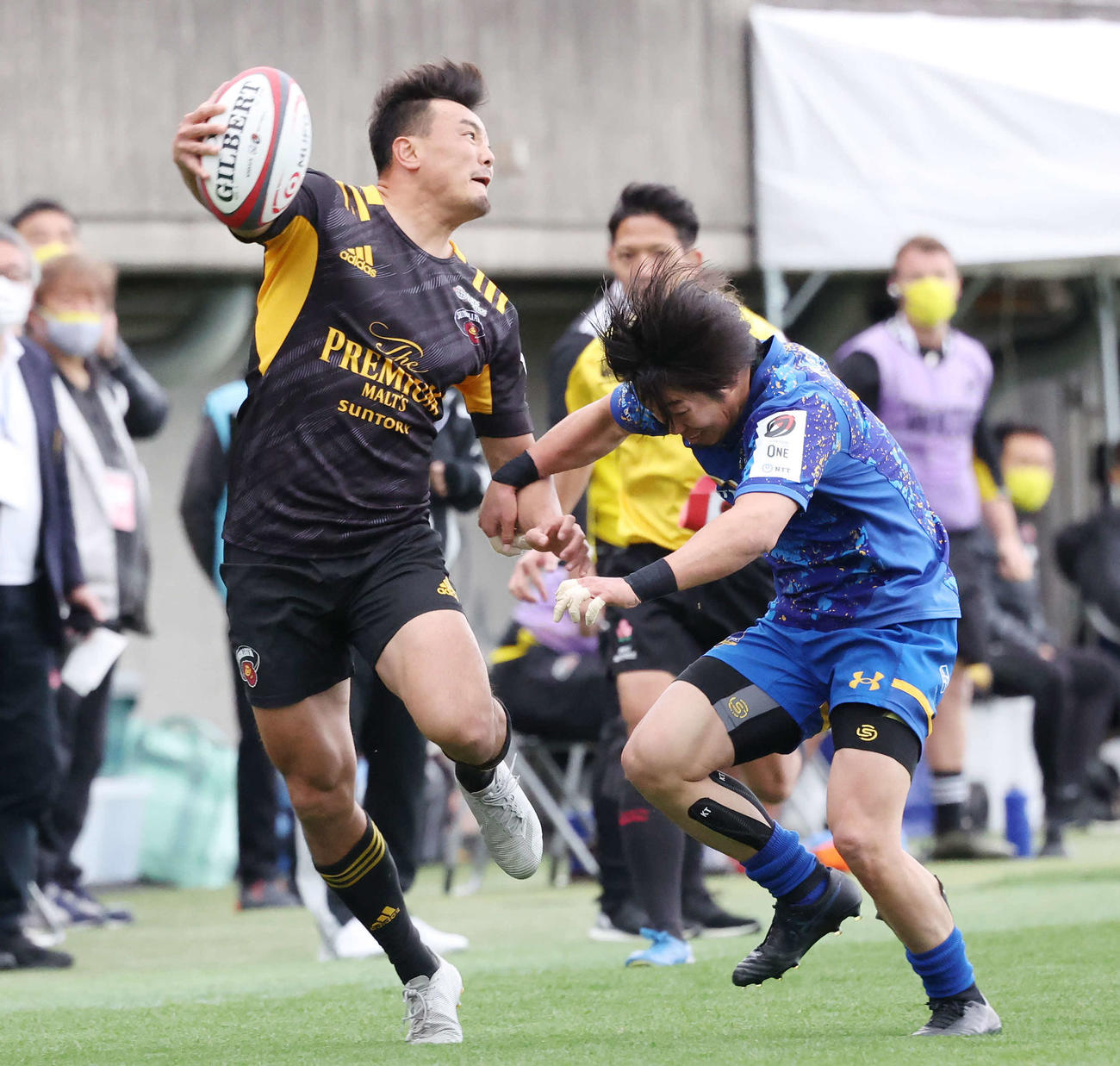 東京SG対浦安　前半、タッチライン際でタックルを受けながらもCTB森谷へのパスを通す東京SGFB尾崎（撮影・丹羽敏通）