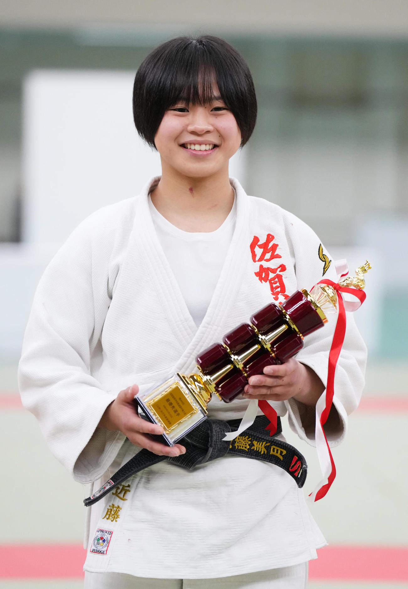 女子団体戦で最終選手に選ばれ、トロフィーを手に笑顔を見せる佐賀商・近藤（撮影・菅敏）