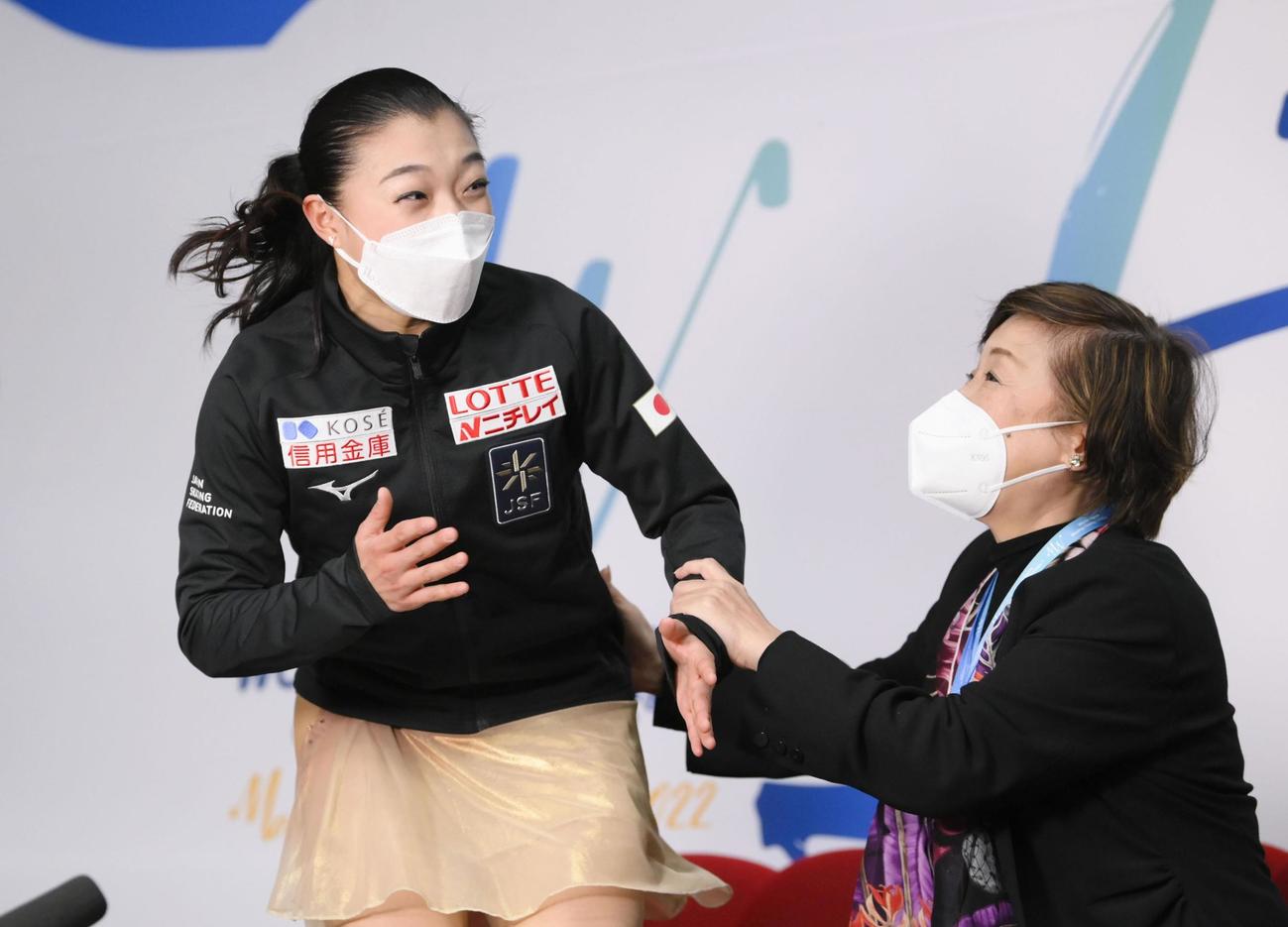女子SP　演技を終え得点を確認し喜ぶ坂本花織（左）（共同）