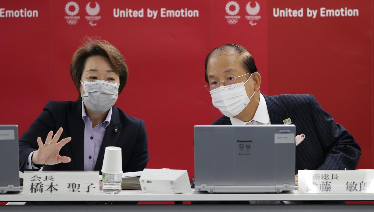 東京五輪・パラリンピック大会組織委員会の理事会の開始前に武藤敏郎事務総長（右）と言葉を交わす橋本聖子会長（代表撮影）
