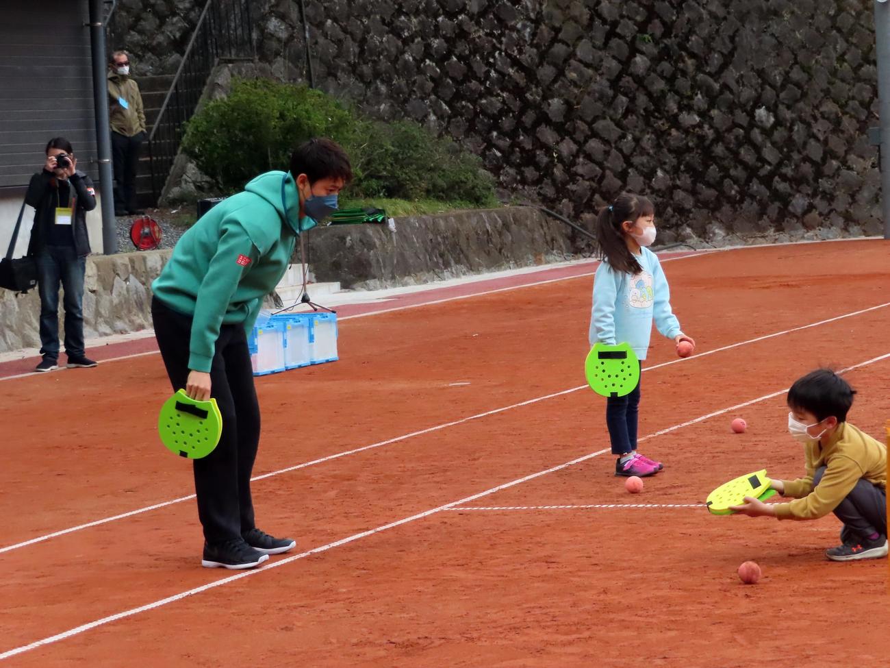 完成記念イベントで子どもにミニテニスを教える錦織