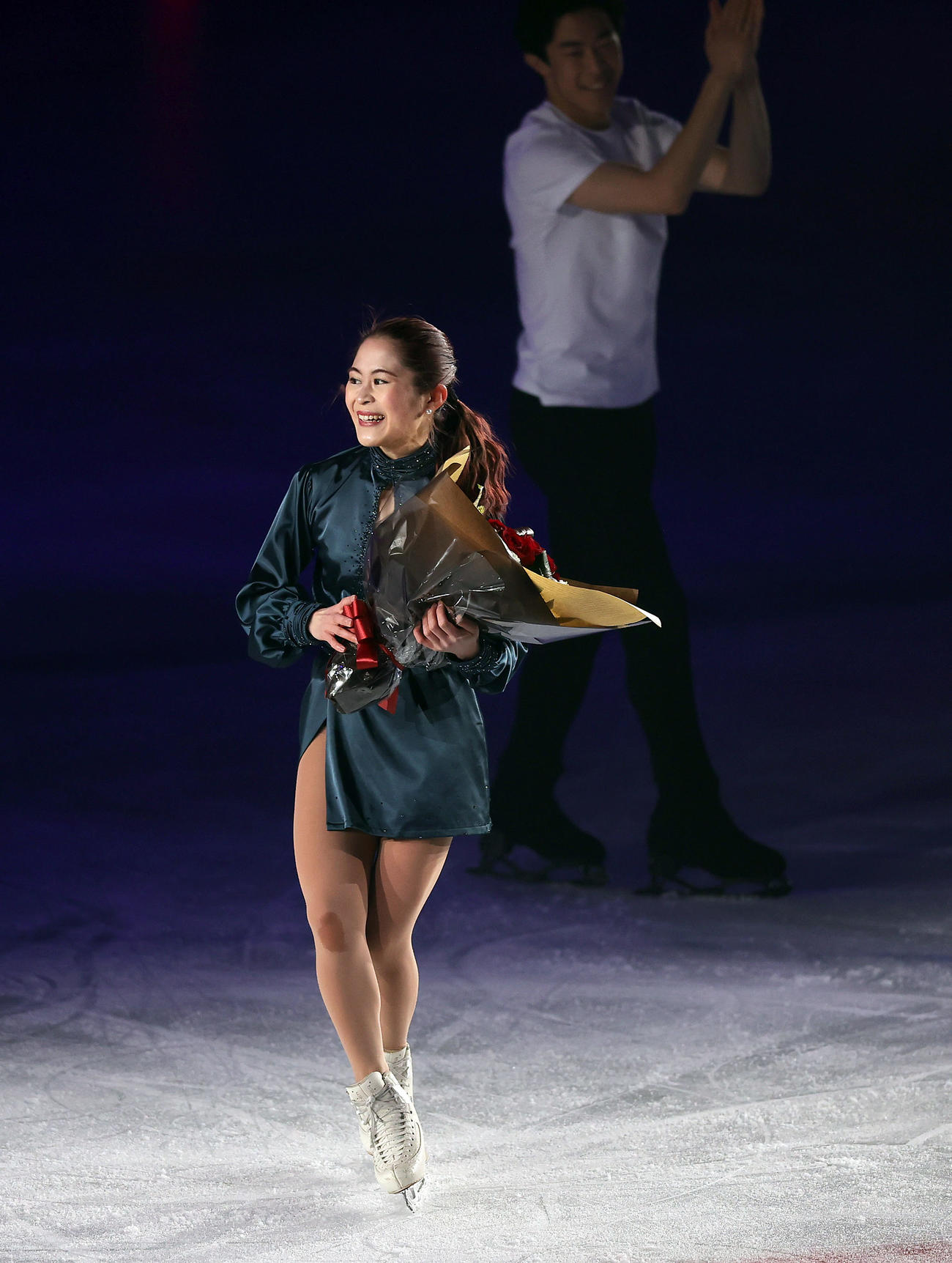 演技を終え、ネーサン・チェン（後方）から花束を受け取り笑顔を見せる宮原さん（撮影・前田充）