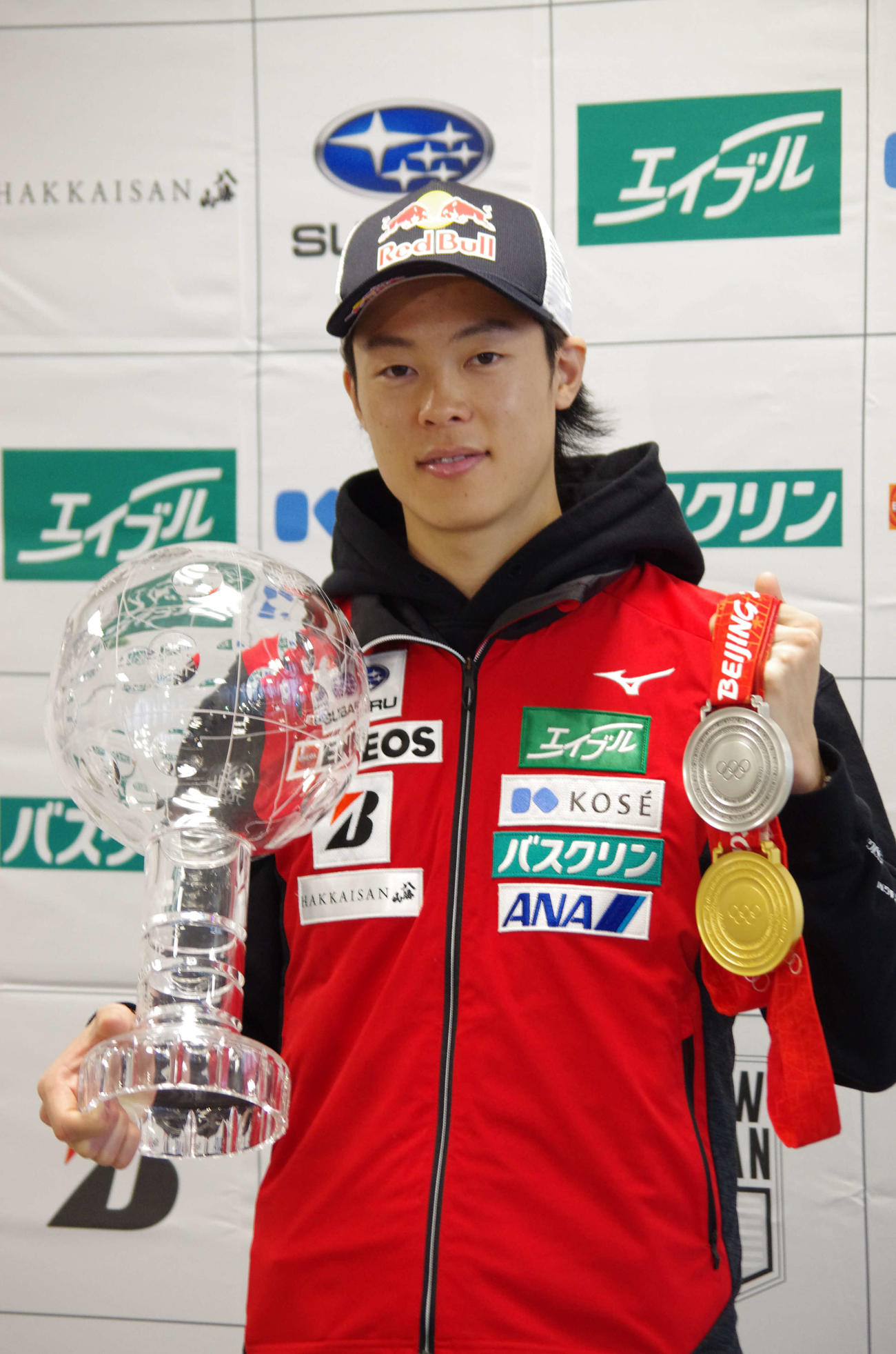 北京五輪で獲得した金銀2つのメダルと、W杯個人総合優勝優勝者に贈られるクリスタルトロフィーを手にするスキージャンプの小林陵（撮影・奥岡幹浩）