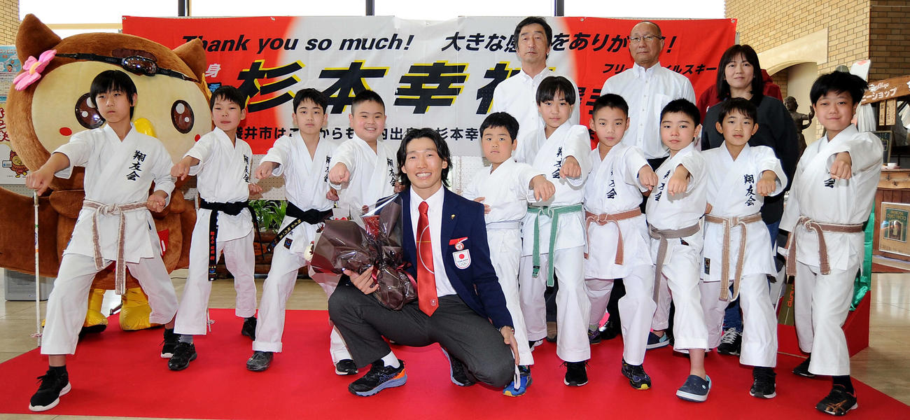 出迎えた翔友会の選手らと記念写真に納まる杉本（前列中央）