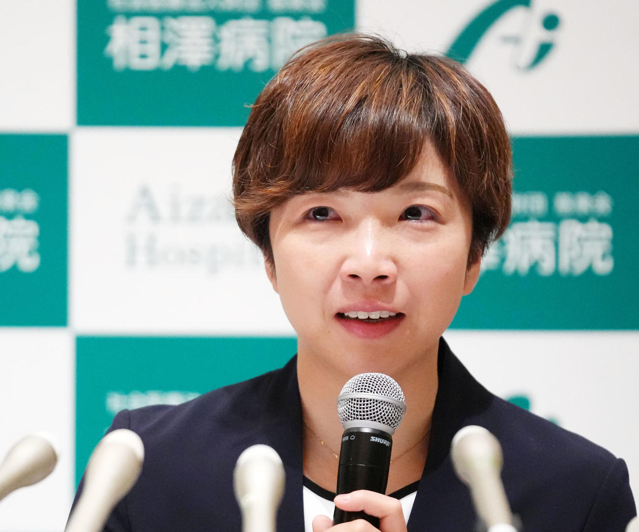 涙をこらえながら質問に答える小平（撮影・横山健太）