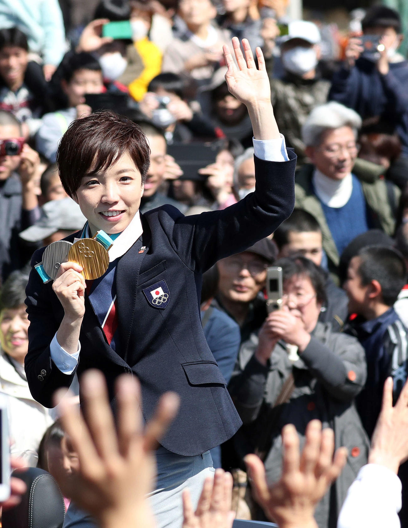 18年3月、平昌五輪で金、銀メダルを獲得した女子スピードスケート小平は報告パレードを行い、沿道からの声援にメダルを掲げて笑顔で応える