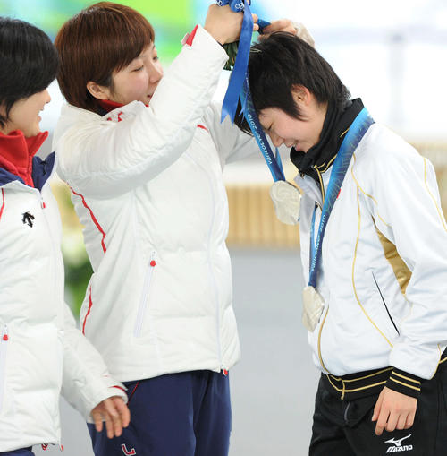 10年2月、バンクーバー五輪スピードスケート女子団体追い抜きで出場機会のなかった高木美（右）は小平にメダルをかけてもらう
