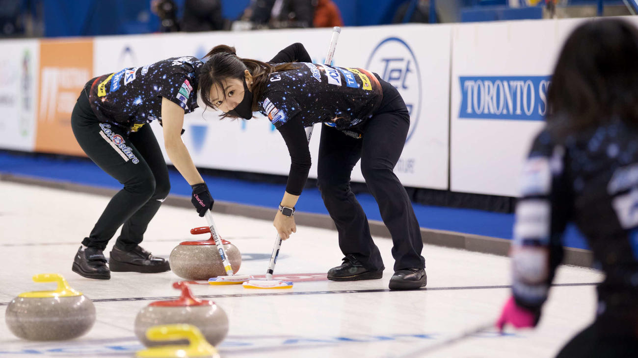 スイープするロコ・ソラーレの吉田知(c)Sportnsnet／Anil Mungal