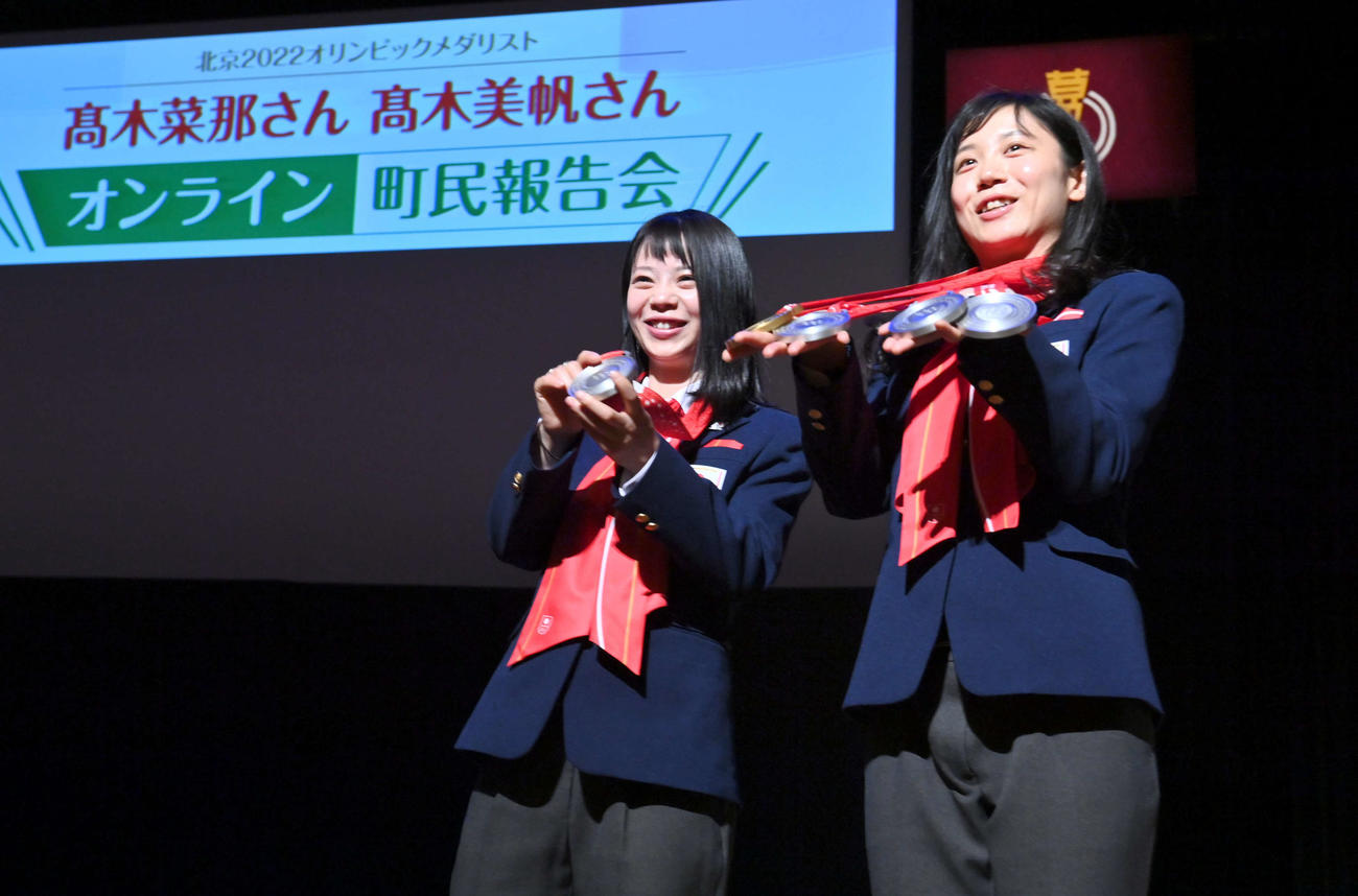 オンライン町民報告会に出席し、北京五輪で獲得したメダルを披露するスピードスケートの高木菜那（左）と美帆姉妹（代表撮影）