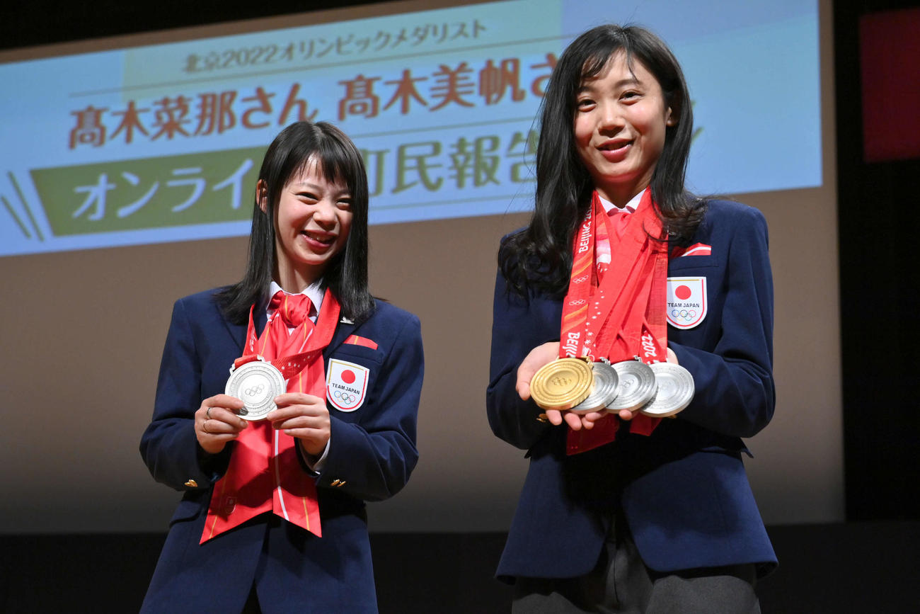 オンライン町民報告会に出席し、北京五輪で獲得したメダルを披露するスピードスケートの高木菜那さん（左）と美帆姉妹（代表撮影）